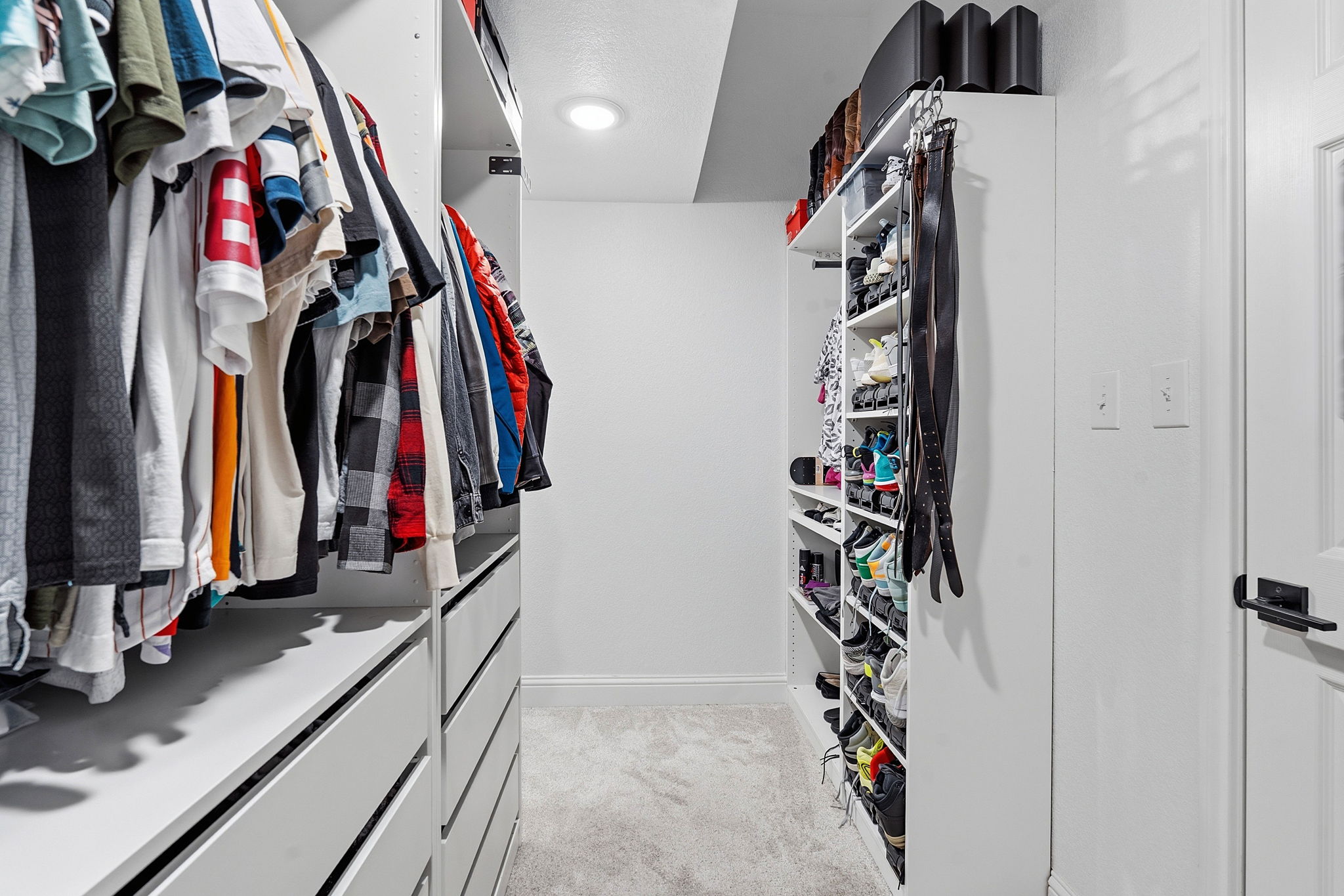 5000 Mission Oaks Boulevard, Unit 30 Austin, TX 78735 - Photo 17 of 31 Primary bedroom Walk in closet with built ins. Primary bathroom with a bath, double vanity, a stall shower, and light tile patterned floors. 5000 Mission Oaks Dr #30