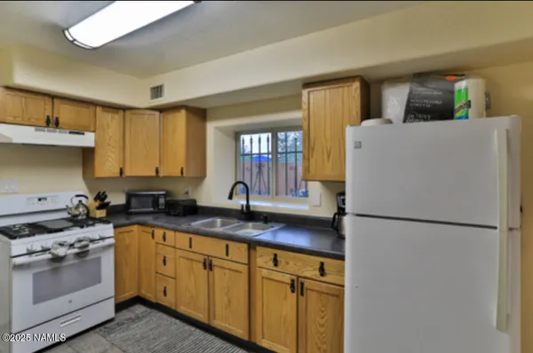 a kitchen with stainless steel appliances granite countertop a refrigerator a stove a sink and a granite counter tops with a large window