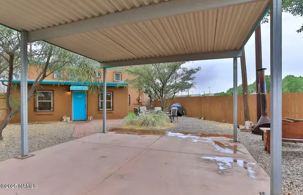 a view of backyard with table and chairs under an umbrella