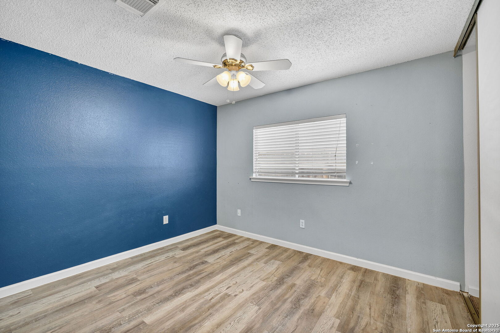 7362 Rustling Brook San Antonio, TX 78249 - Photo 25 of 36 an empty room with a chandelier fan and windows