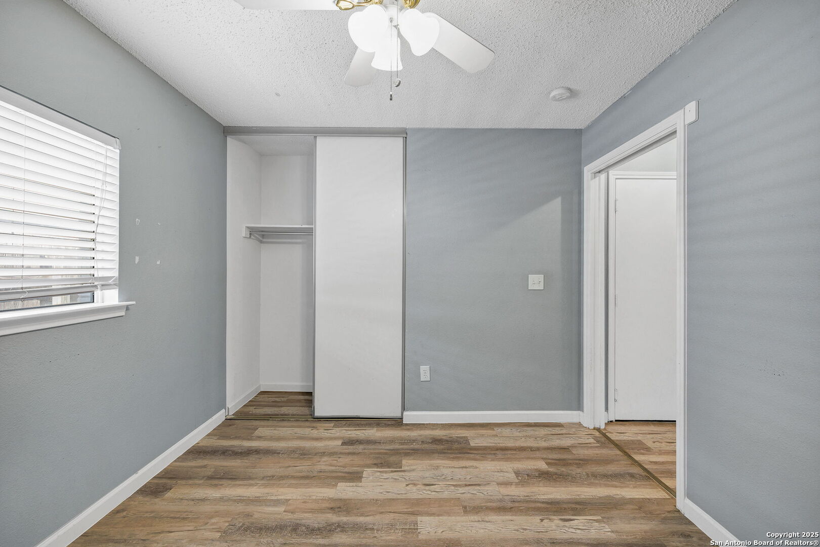 7362 Rustling Brook San Antonio, TX 78249 - Photo 27 of 36 a view of an empty room with window and wooden floor