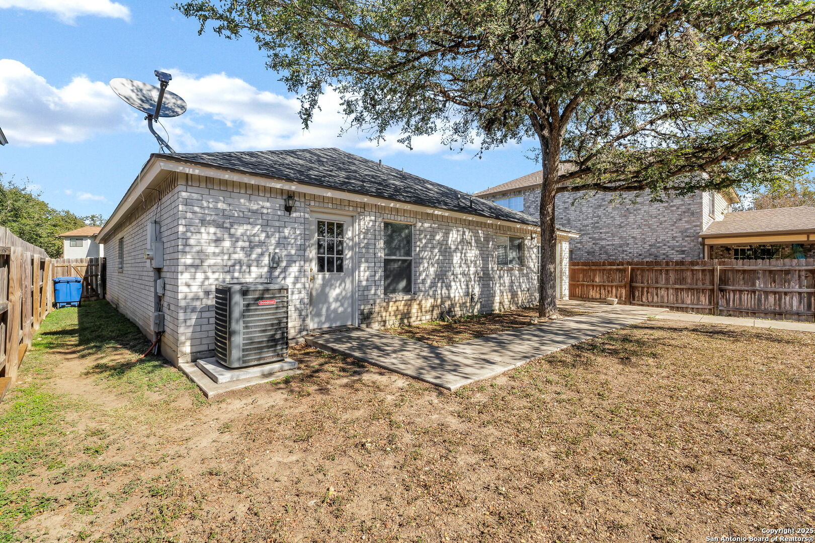 7362 Rustling Brook San Antonio, TX 78249 - Photo 35 of 36 a view of a house with a large tree and wooden fence