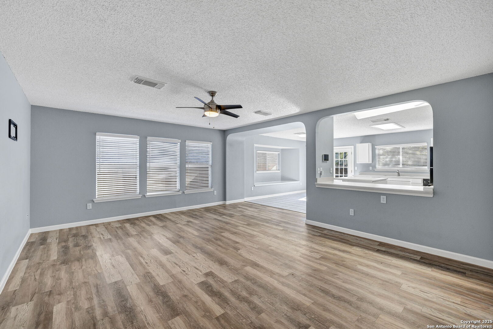 7362 Rustling Brook San Antonio, TX 78249 - Photo 6 of 36 a view of an empty room with wooden floor and a window