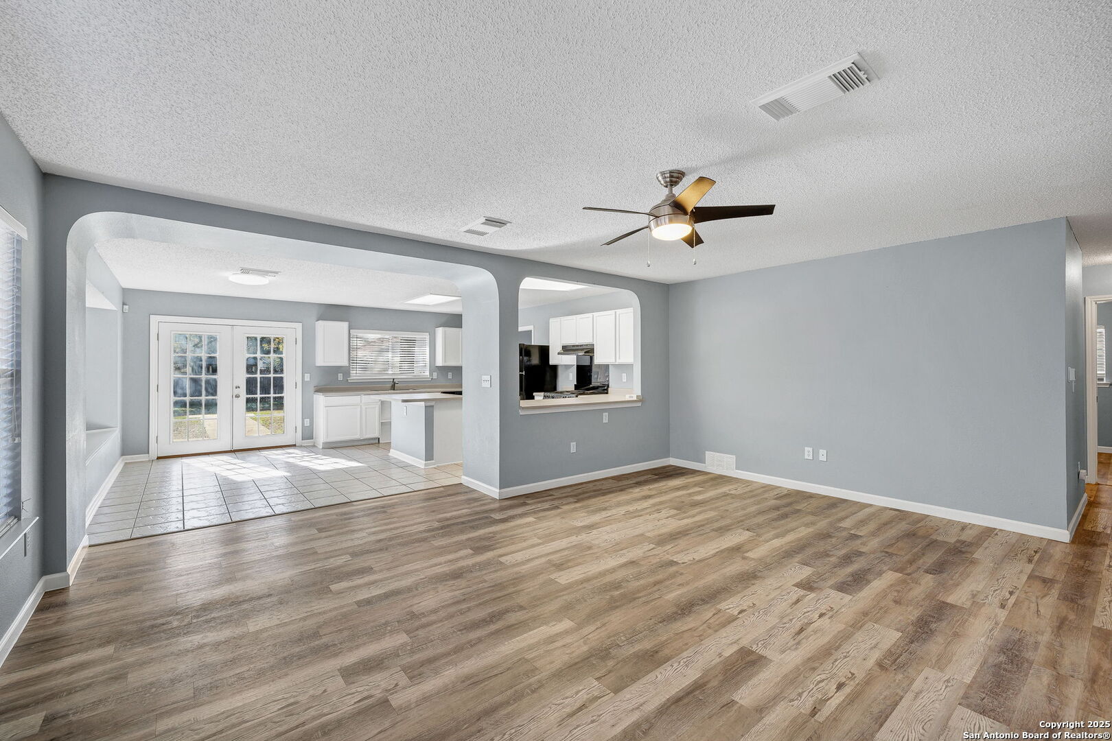 7362 Rustling Brook San Antonio, TX 78249 - Photo 7 of 36 a view of an empty room with a window and wooden floor