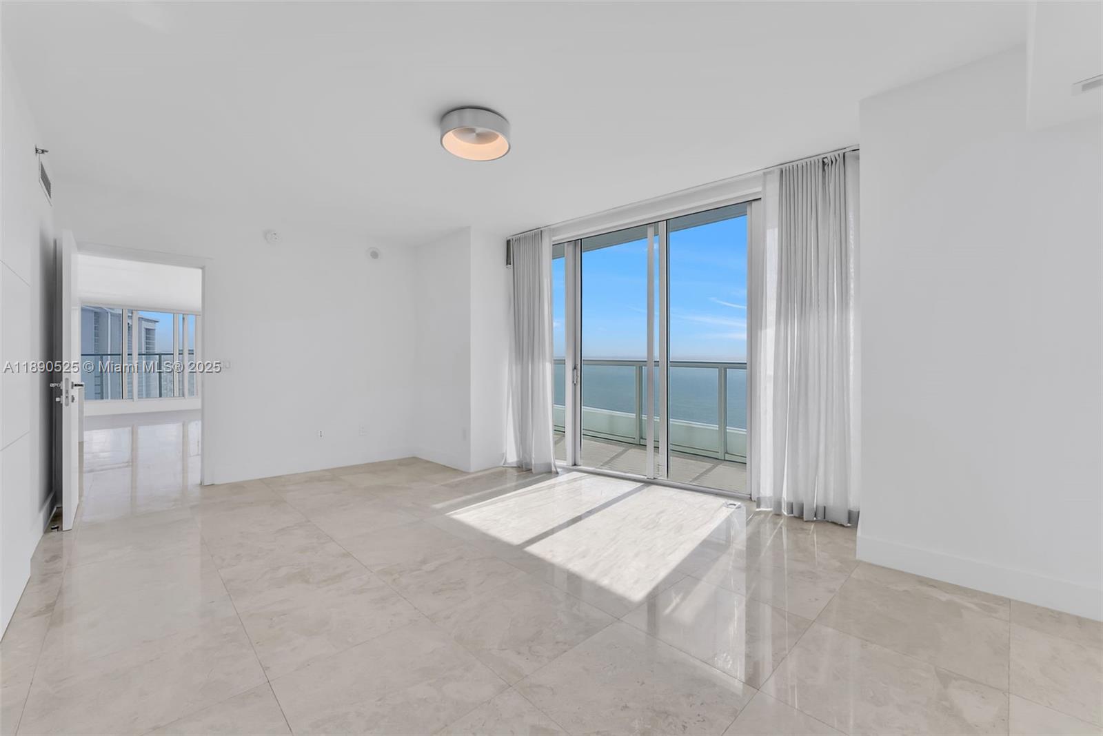 465 Brickell Avenue, Unit 4201 Miami, FL 33131 - Photo 5 of 16 an empty room with sliding glass door and chandelier fan