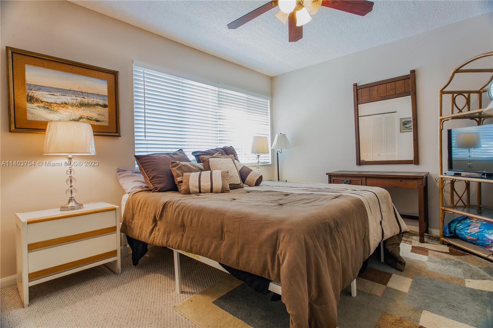894 Southwest 9th St Circle, Unit 8 Boca Raton, FL 33486 - Photo 13 of 24 a bedroom with a bed and a night stand