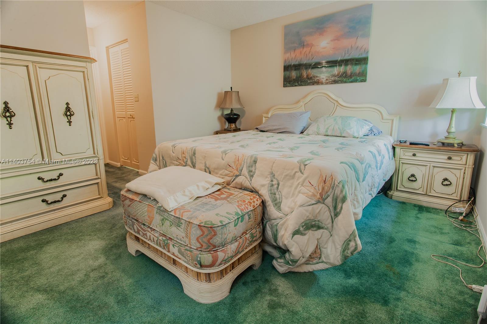894 Southwest 9th St Circle, Unit 8 Boca Raton, FL 33486 - Photo 17 of 24 a spacious bedroom with a bed and dresser