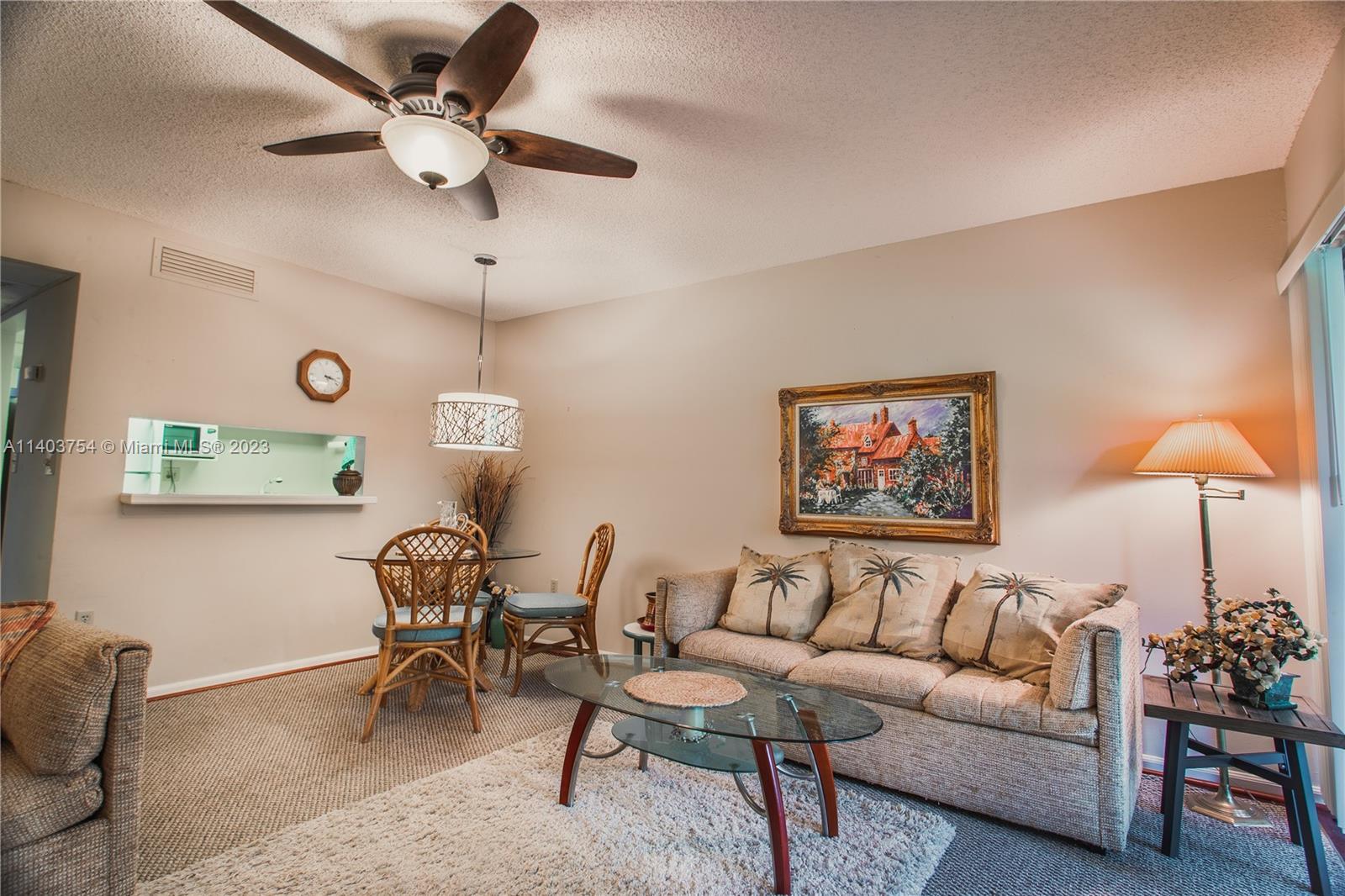 894 Southwest 9th St Circle, Unit 8 Boca Raton, FL 33486 - Photo 2 of 24 a living room with furniture and a lamp