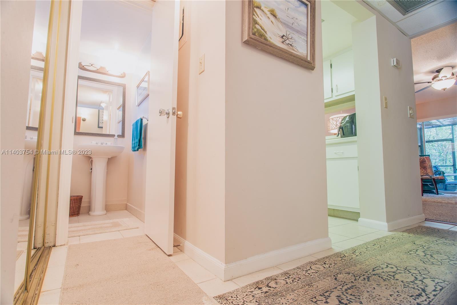 894 Southwest 9th St Circle, Unit 8 Boca Raton, FL 33486 - Photo 8 of 24 a view of a hallway with paintings on the wall