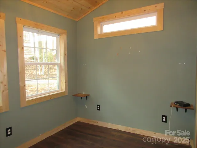 a view of a room with wooden floor and windows