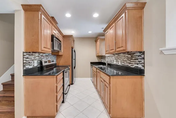 a kitchen with stainless steel appliances granite countertop a stove and a refrigerator