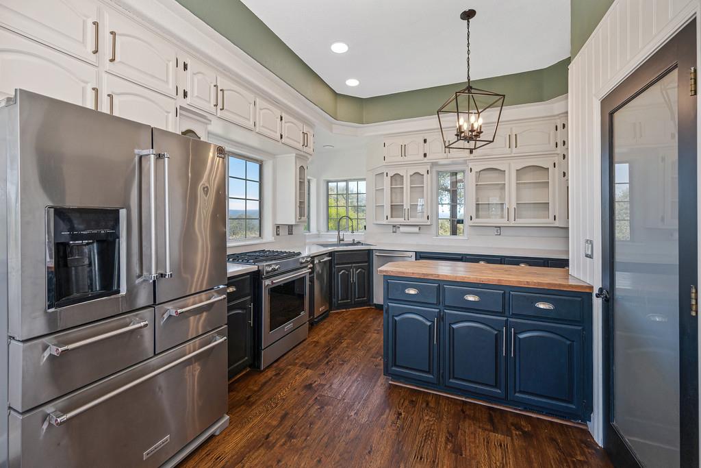 3154 Twin K Road Pilot Hill, CA 95664 - Photo 38 of 89 a large kitchen with stainless steel appliances granite countertop a refrigerator a sink dishwasher a dining table and chairs with wooden floor