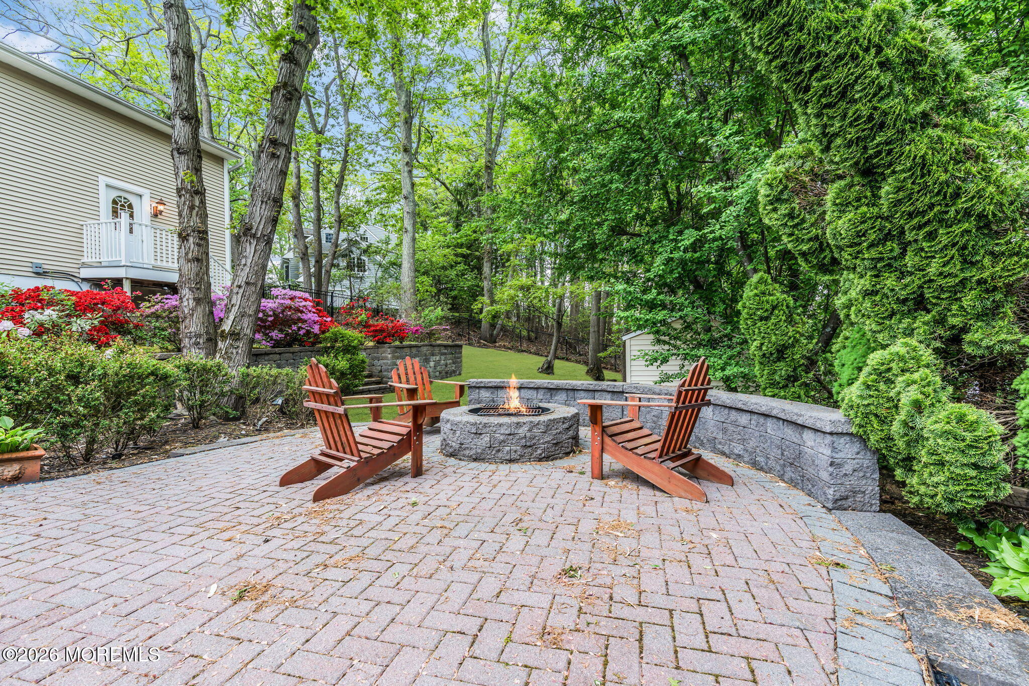 657 Valley Road Brielle, NJ 08730 - Photo 40 of 44 a wooden bench sitting in backside of a house with potted plants and large trees