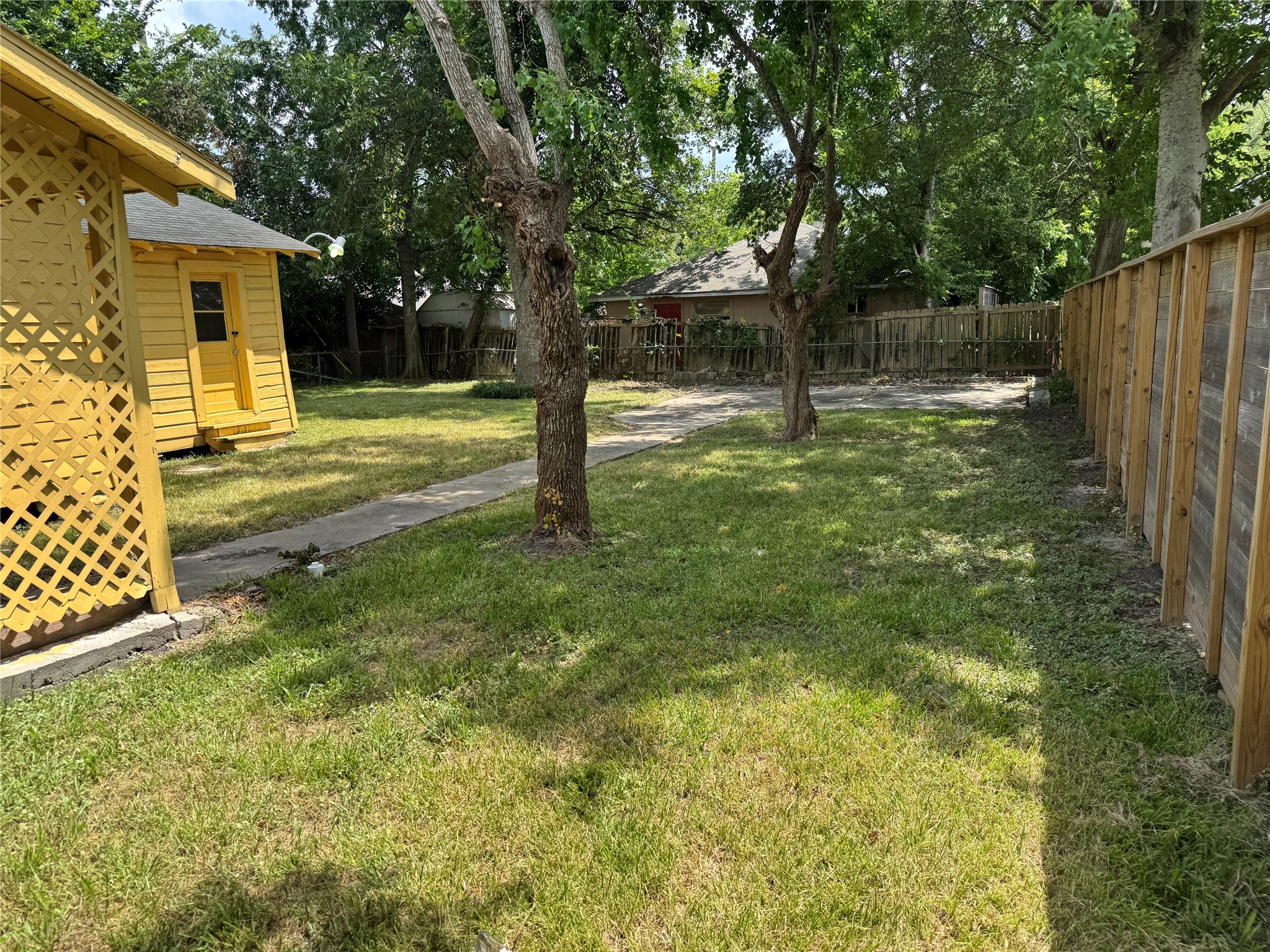 606 East 42nd Street Houston, TX 77022 - Photo 4 of 14 a view of a trees in front of a yard with wooden fence