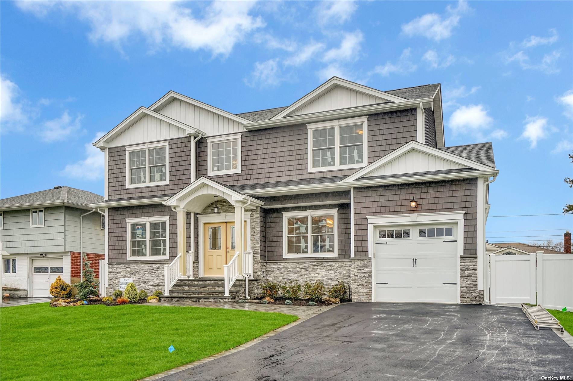 a front view of a house with a yard and trees