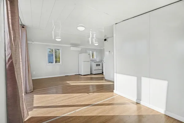 a view of a livingroom with wooden floor and windows
