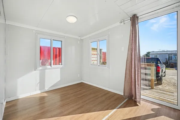 a view of a room with wooden floor and windows