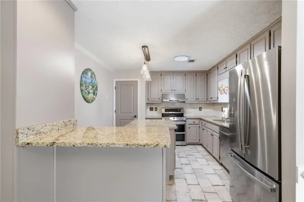 a kitchen with granite countertop a sink stainless steel appliances and cabinets