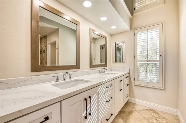 a bathroom with double sink and a mirror