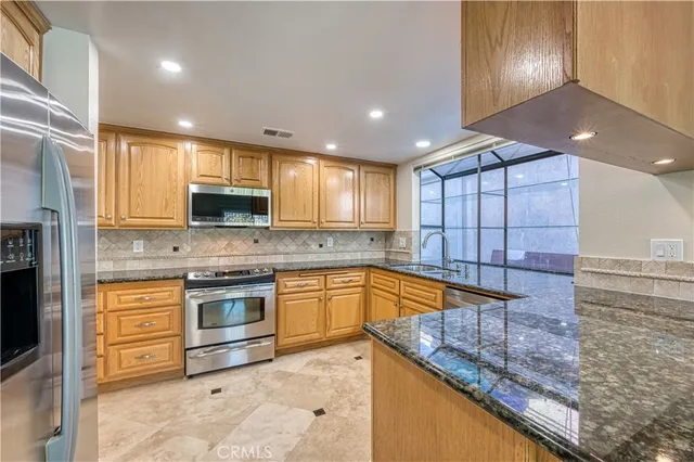a kitchen with stainless steel appliances granite countertop a sink and cabinets