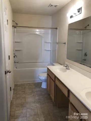 a bathroom with a sink toilet double vanity and shower