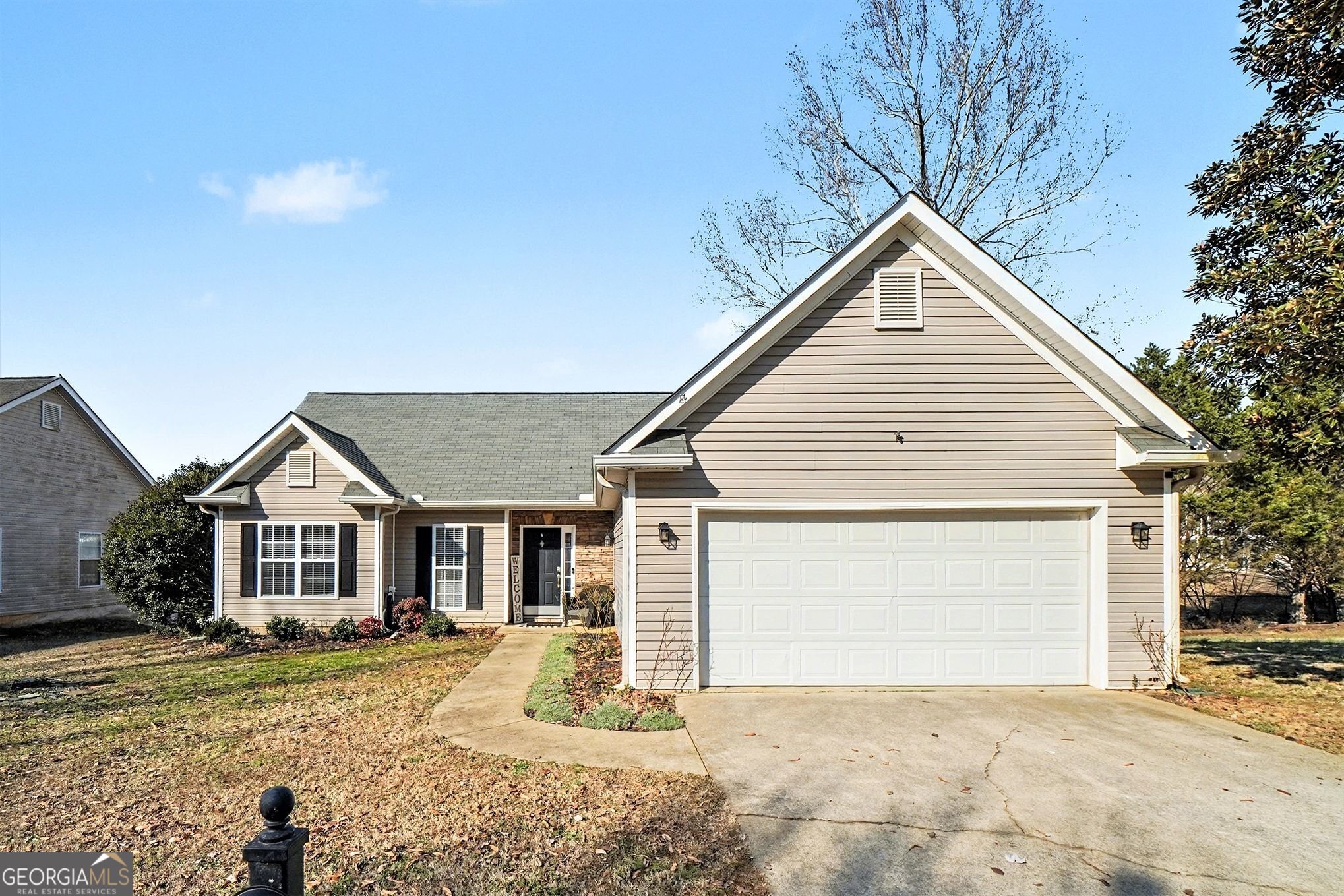 a view of a house with a yard and large tree