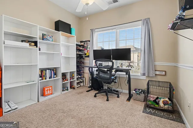a view of a workspace with furniture and a window