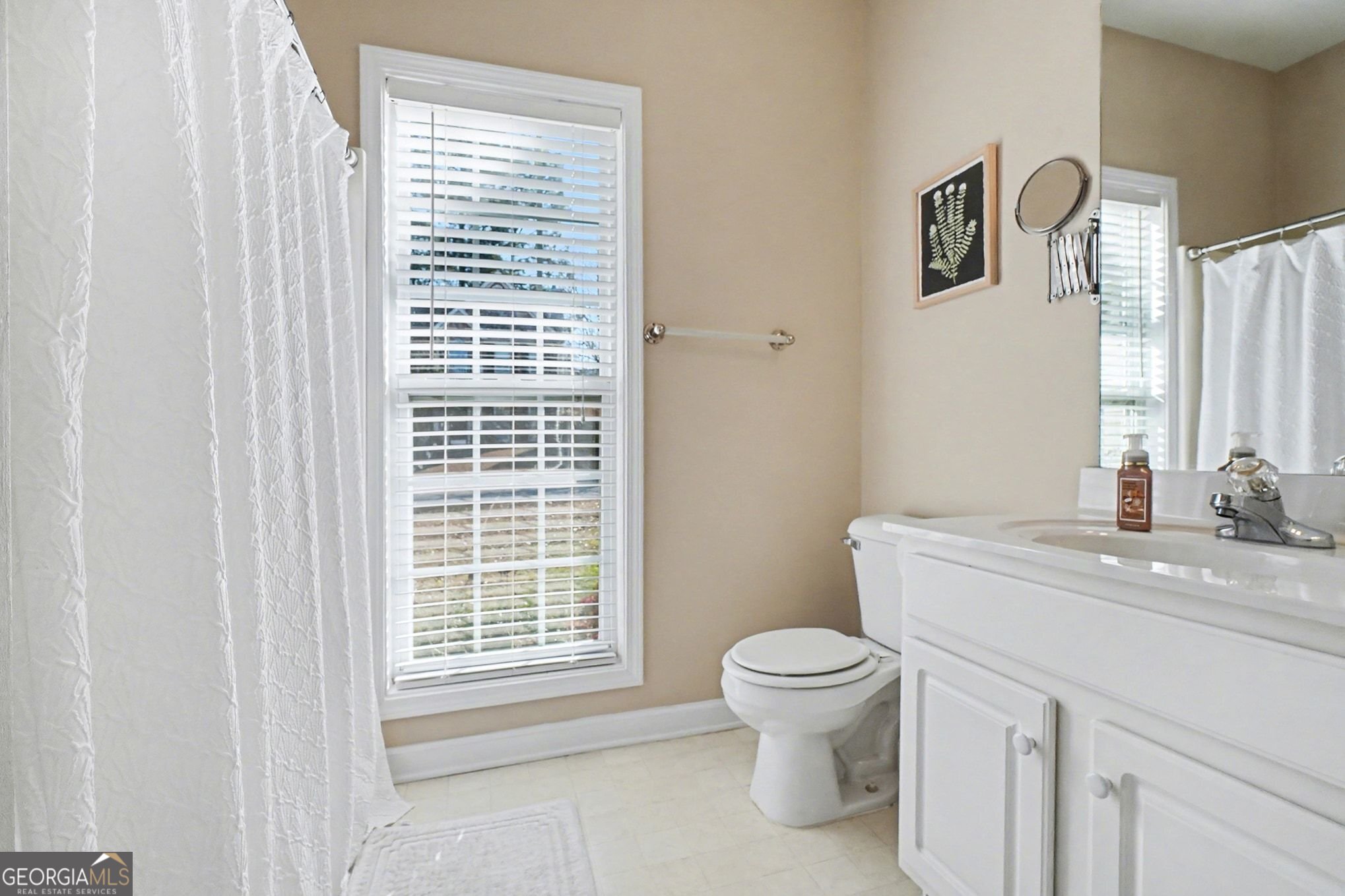 310 Turtle Pointe Drive Carrollton, GA 30116 - Photo 15 of 32 a bathroom with a granite countertop toilet a sink a mirror a window and a shower