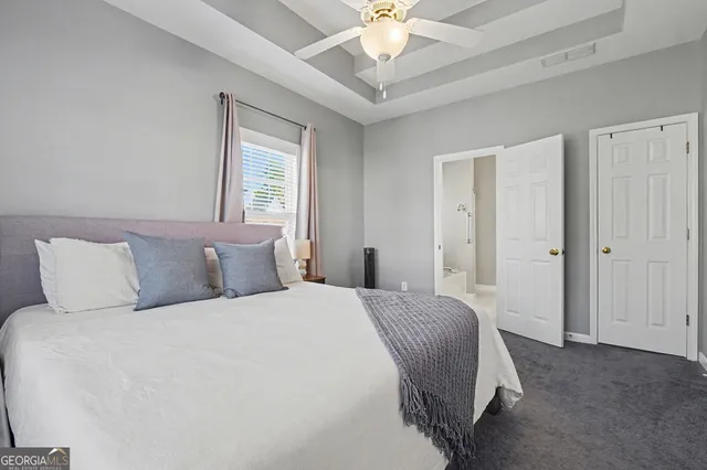 a bedroom with a large bed and a chandelier