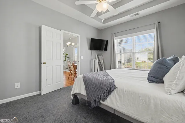 a bedroom with a bed a flat screen tv and a large window