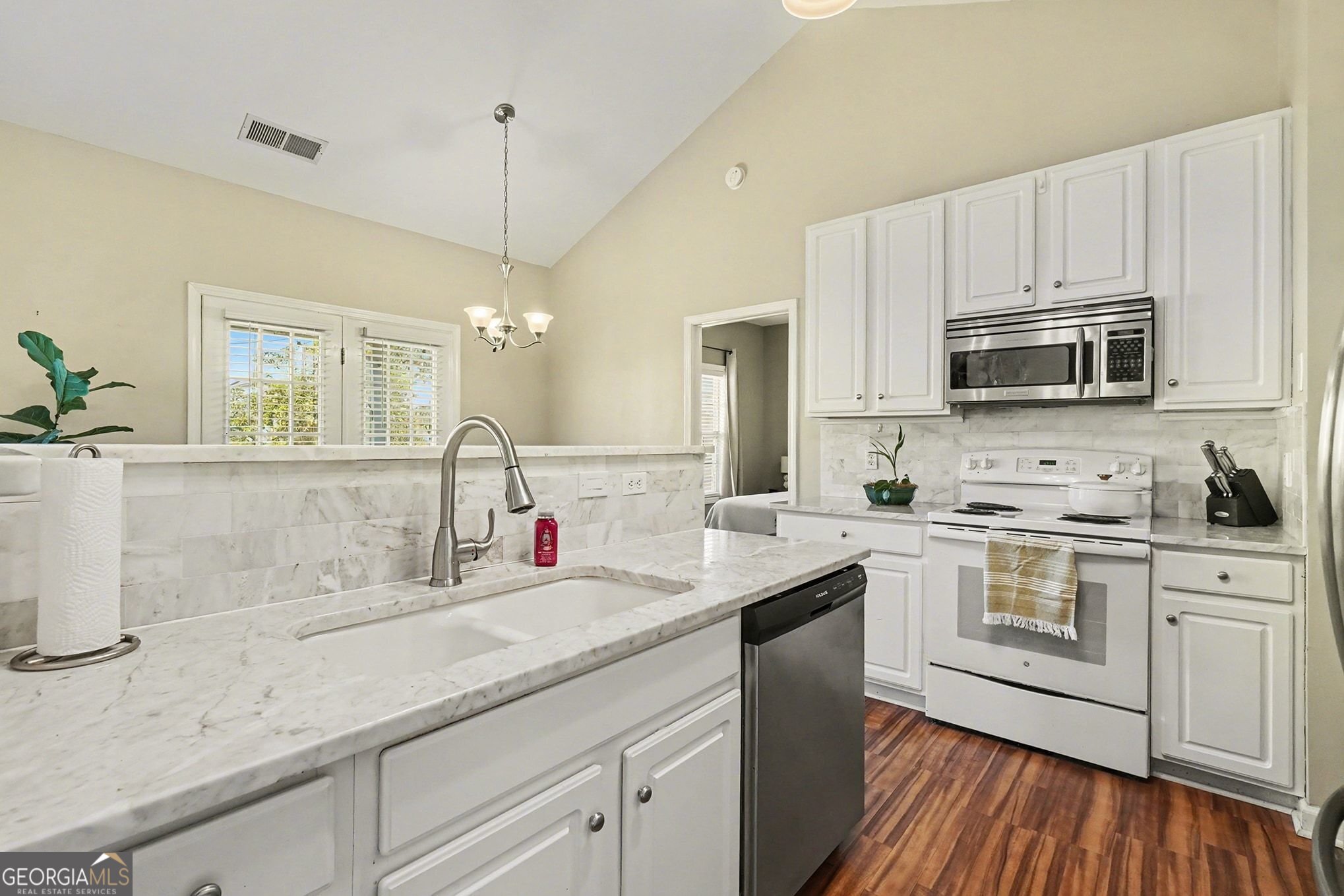 310 Turtle Pointe Drive Carrollton, GA 30116 - Photo 10 of 32 a kitchen with appliances a sink cabinets and a wooden floor