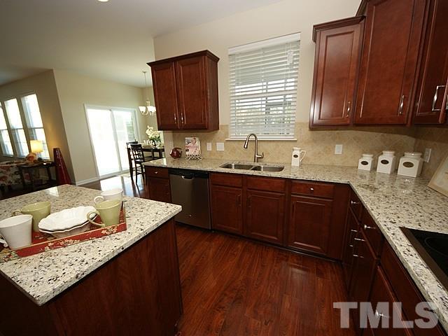 2705 Communion Court Raleigh, NC 27610 - Photo 7 of 24 a kitchen with granite countertop lots of counter top space a sink a stove and dining table