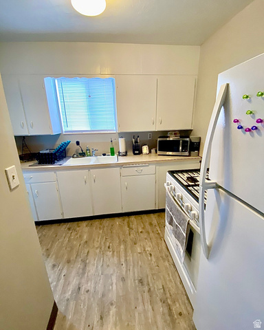620 East 600 North Logan, UT 84321 - Photo 6 of 13 Kitchen with white appliances, white cabinetry, light countertops, and light wood-style flooring