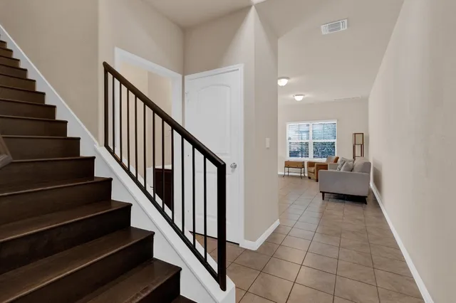 a view of a livingroom with wooden floor and stairs