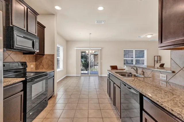 a kitchen with stainless steel appliances granite countertop a sink stove and cabinets