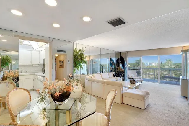 a dining room with furniture and a large window