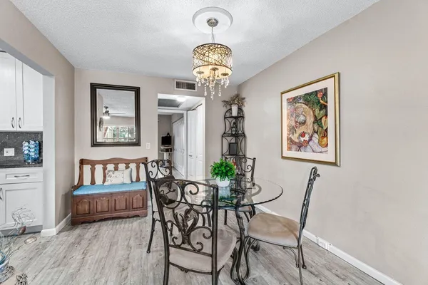 a view of a dining room with furniture a chandelier and wooden floor