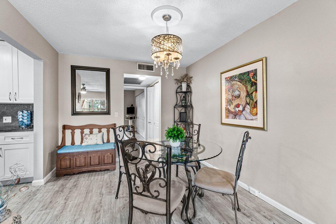 3 Mansfield B Boca Raton, FL 33434 - Photo 12 of 35 a view of a dining room with furniture a chandelier and wooden floor
