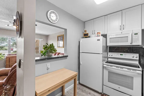 a white refrigerator freezer and a stove sitting inside of a kitchen