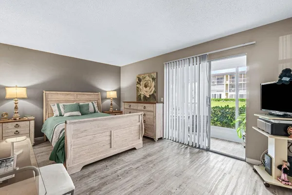 a bedroom with a bed and a flat screen tv on the dresser