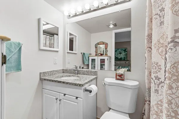 a bathroom with a granite countertop sink and a mirror