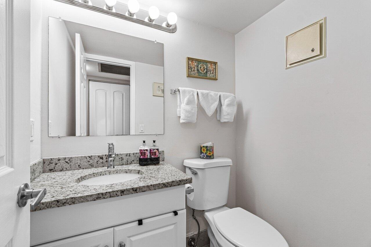 3 Mansfield B Boca Raton, FL 33434 - Photo 24 of 35 a bathroom with a granite countertop toilet sink and mirror