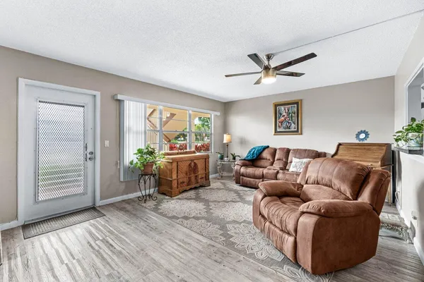 a living room with furniture a ceiling fan and a window