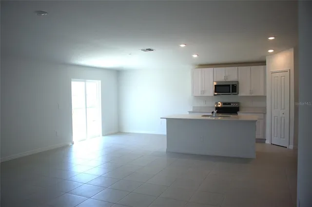 a view of kitchen with microwave oven stove and cabinets