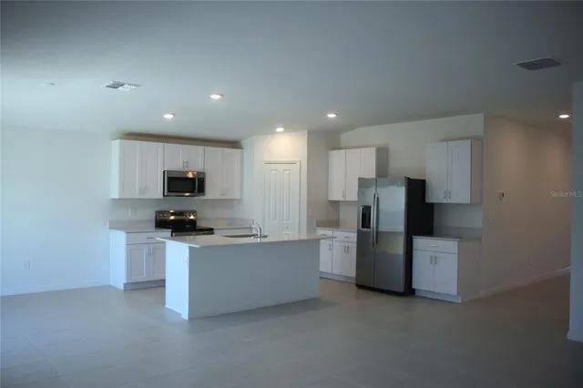 a kitchen with stainless steel appliances a refrigerator and a stove top oven