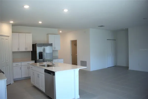 a kitchen with kitchen island sink stove and refrigerator