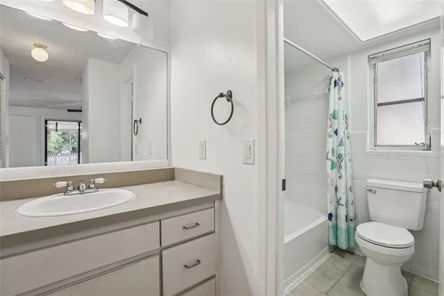a bathroom with a granite countertop toilet sink and mirror