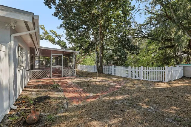 a view of a porch with a small yard and large tree