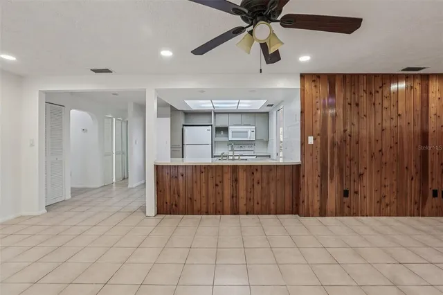 an empty room with ceiling fan and wooden floor