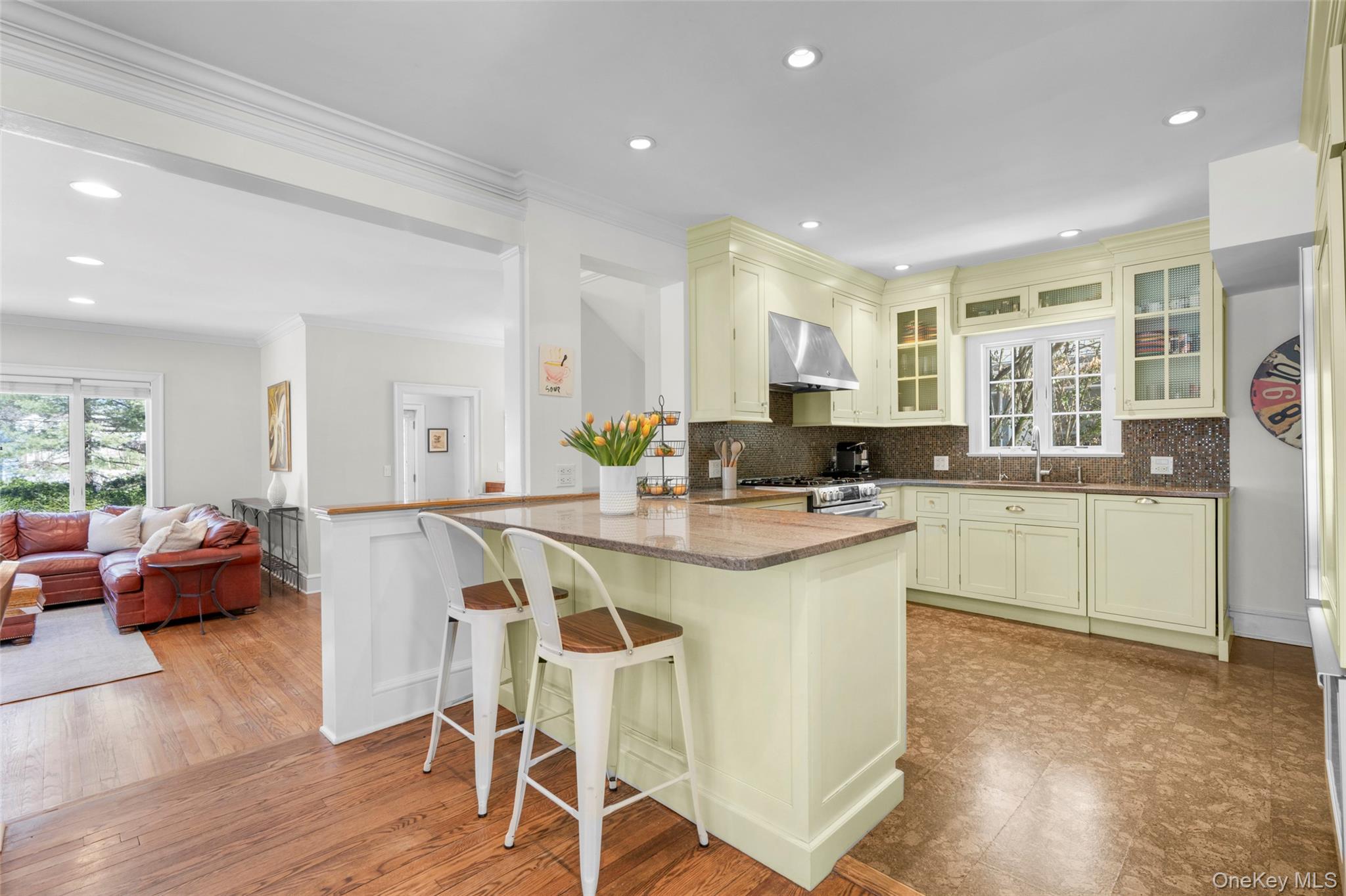 7 Poplar Road Larchmont, NY 10538 - Photo 10 of 46 a kitchen with stainless steel appliances granite countertop a stove top oven a sink a refrigerator white cabinets and couches with wooden floor